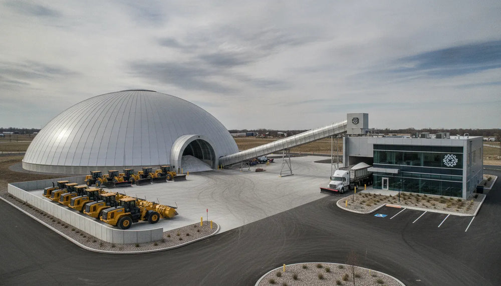 
                  Bulk salt storage and handling dome with loaders and trucks at a commercial property.
                