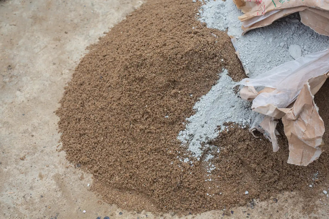 Concrete sand and mason sand beside a bag of cement.