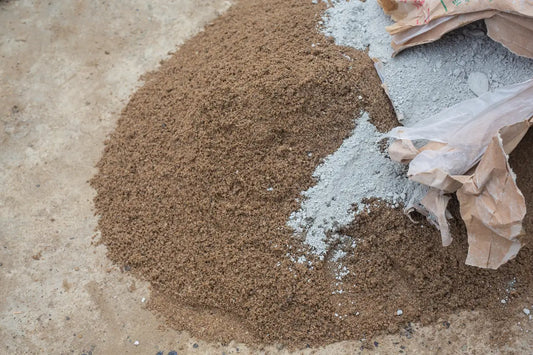 Concrete sand and mason sand beside a bag of cement.